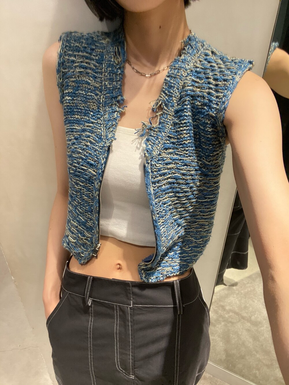 ブラック系のサンダル、ブラック系のスカート、ブルー系のベストを着用したレディースの夏コーディネートの6枚目の写真