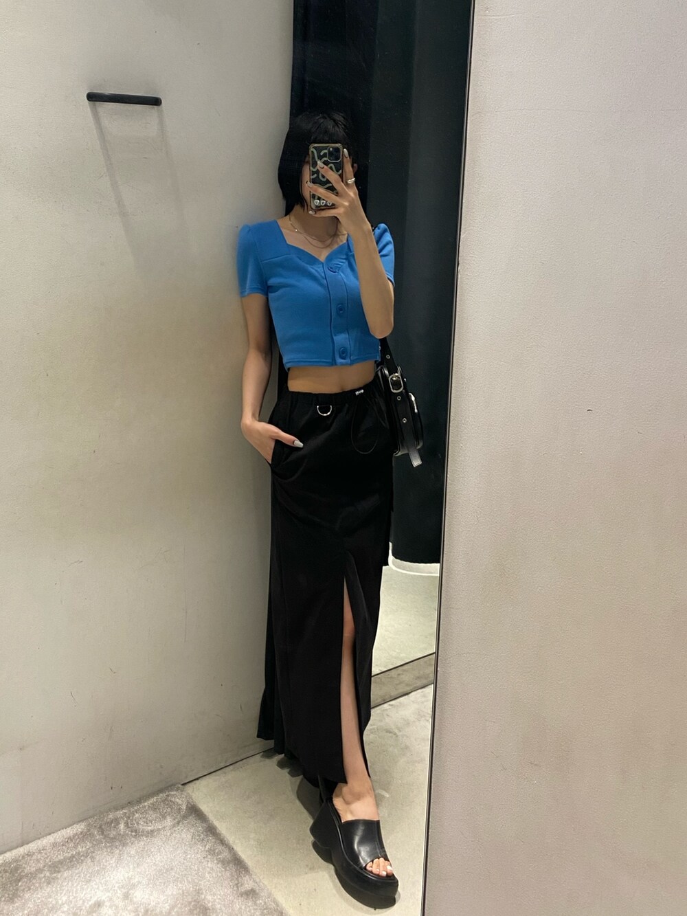 ブラック系のサンダル、ブラック系のスカート、ブルー系のTシャツ/カットソーを着用したレディースの春コーディネートの3枚目の写真