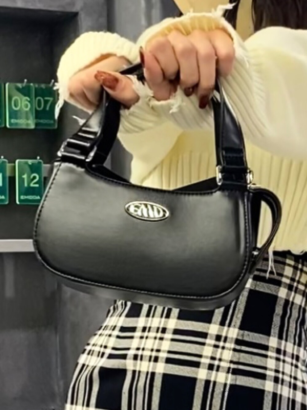 ブラック系のブーツ、ブラック系のハンドバッグ、その他のスカートを着用したレディースの冬コーディネートの8枚目の写真