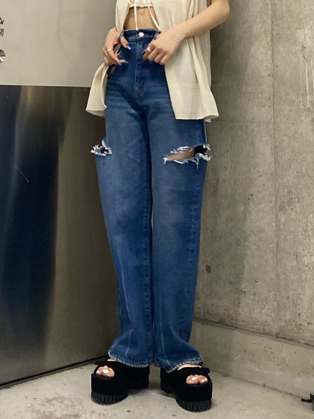 ブラック系のサンダル、ブルー系のデニムパンツ、ホワイト系のTシャツ/カットソーを着用したレディースの夏コーディネートの7枚目の写真