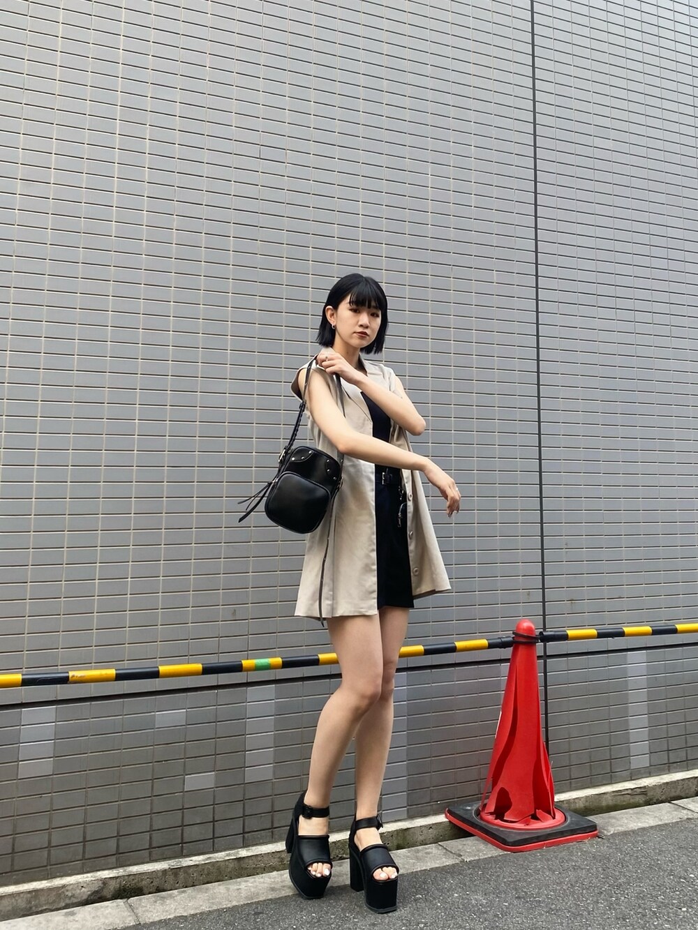 ブラック系のサンダル、ホワイト系のワンピース、ブラック系のニット/セーターを着用したレディースの春コーディネートの2枚目の写真