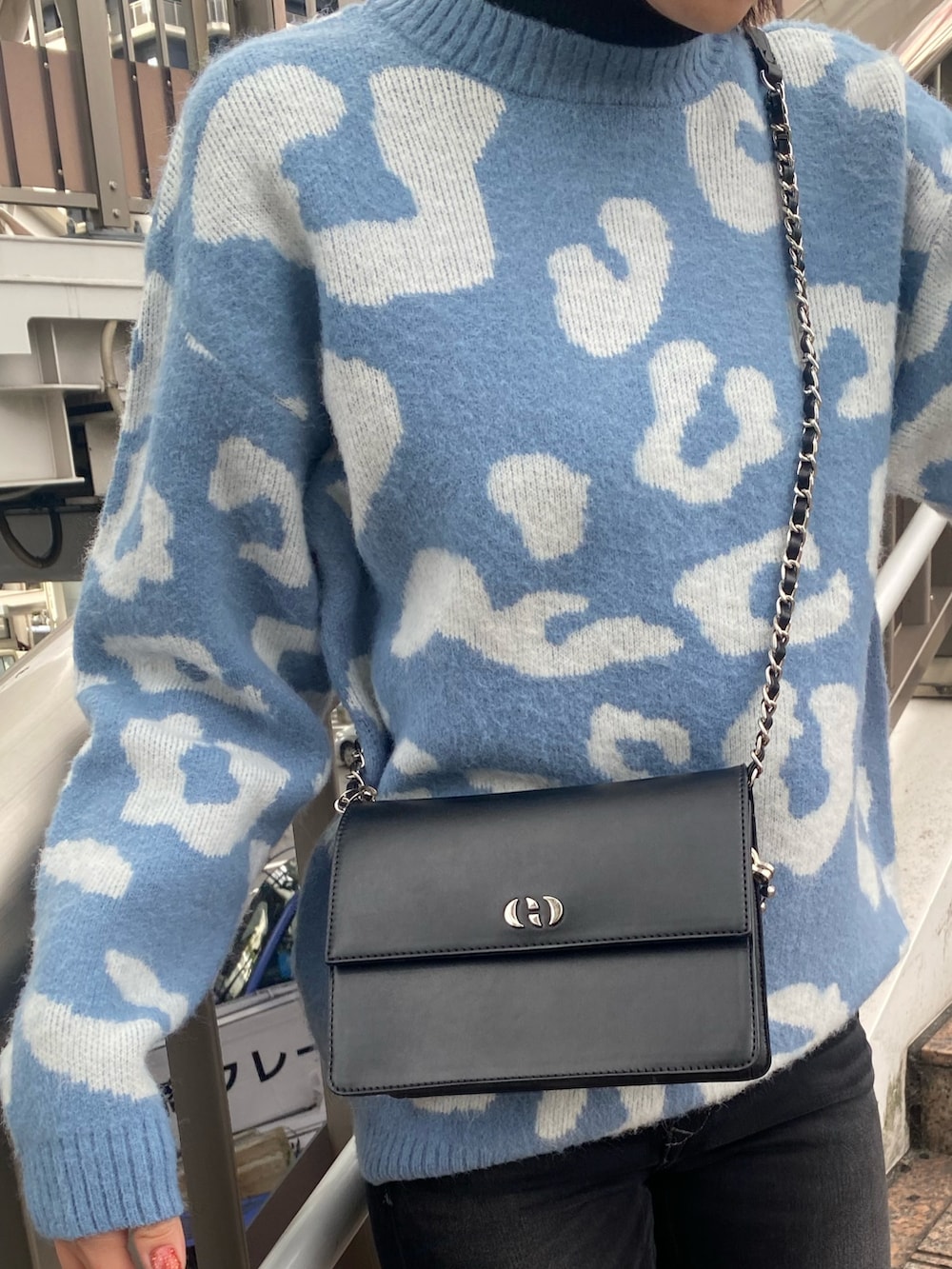 ブルー系のニット/セーター、ブラック系のハンドバッグ、ブラック系のブーツを着用したレディースの冬コーディネートの7枚目の写真