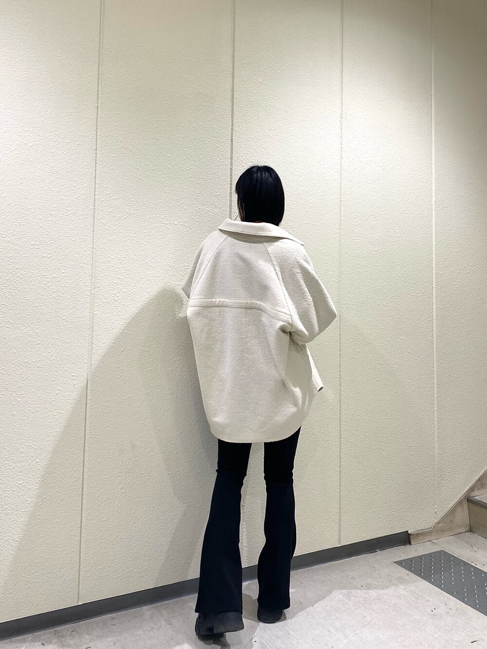 ホワイト系のブルゾン、ブラック系のその他パンツ、ブラック系のブーツを着用したレディースの冬コーディネートの3枚目の写真