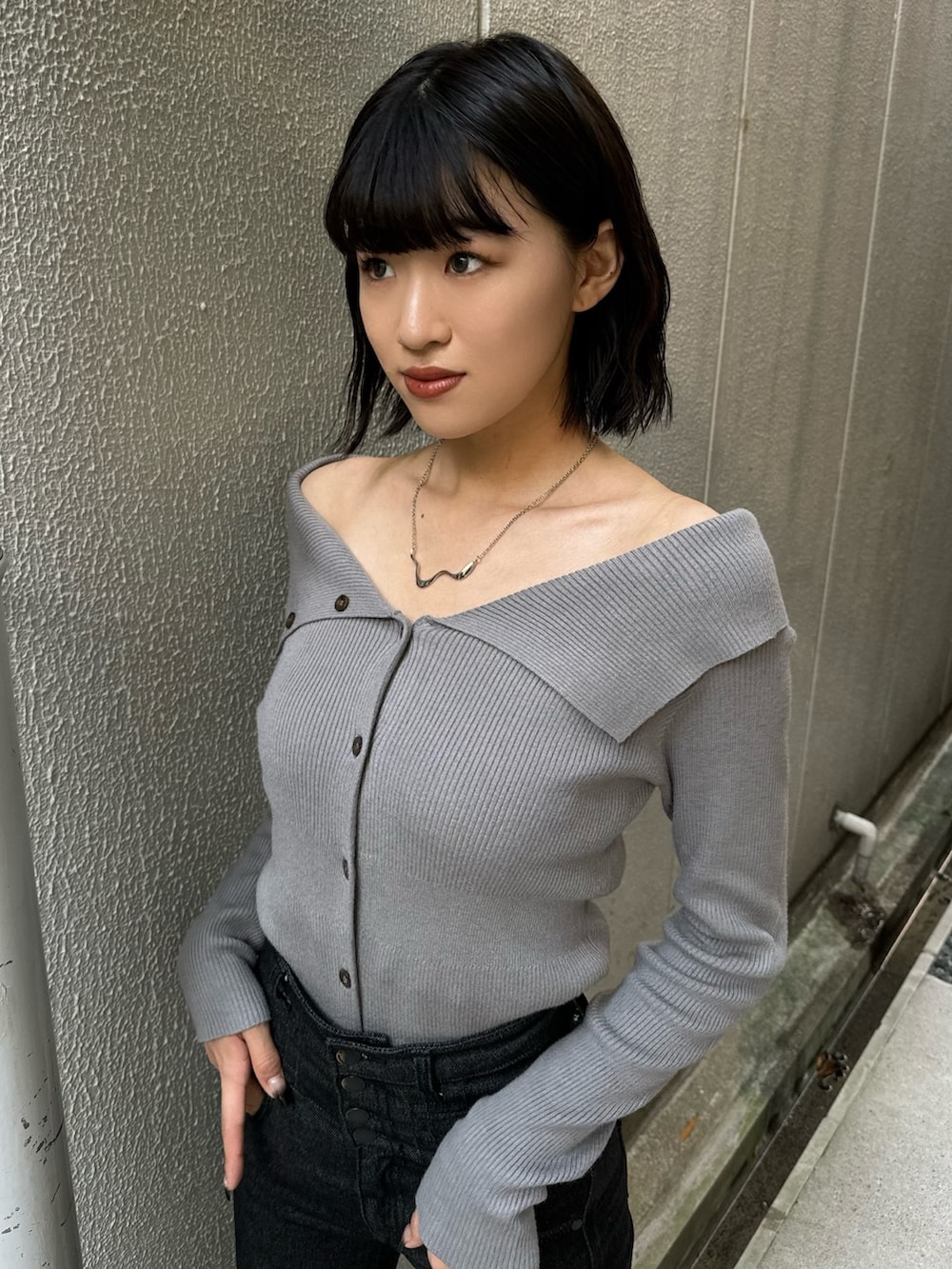 ブラック系のデニムパンツ、ブラック系のブーツ、グレー系のニット/セーターを着用したレディースの秋コーディネートの7枚目の写真