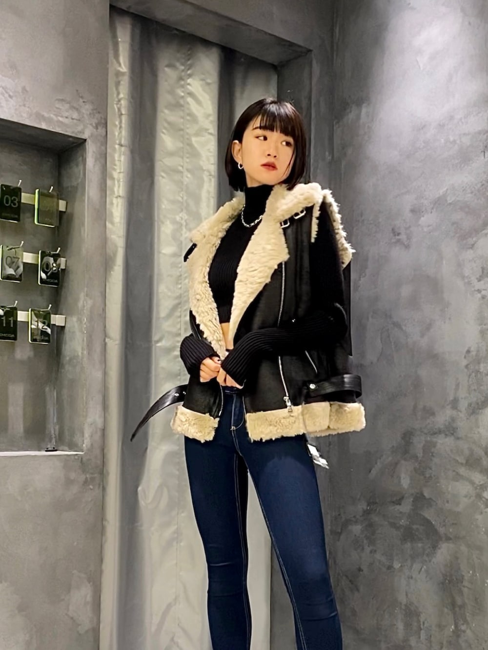 ブルー系のデニムパンツ、ブラック系のブーツ、ブラック系のベストを着用したレディースの秋コーディネートの3枚目の写真