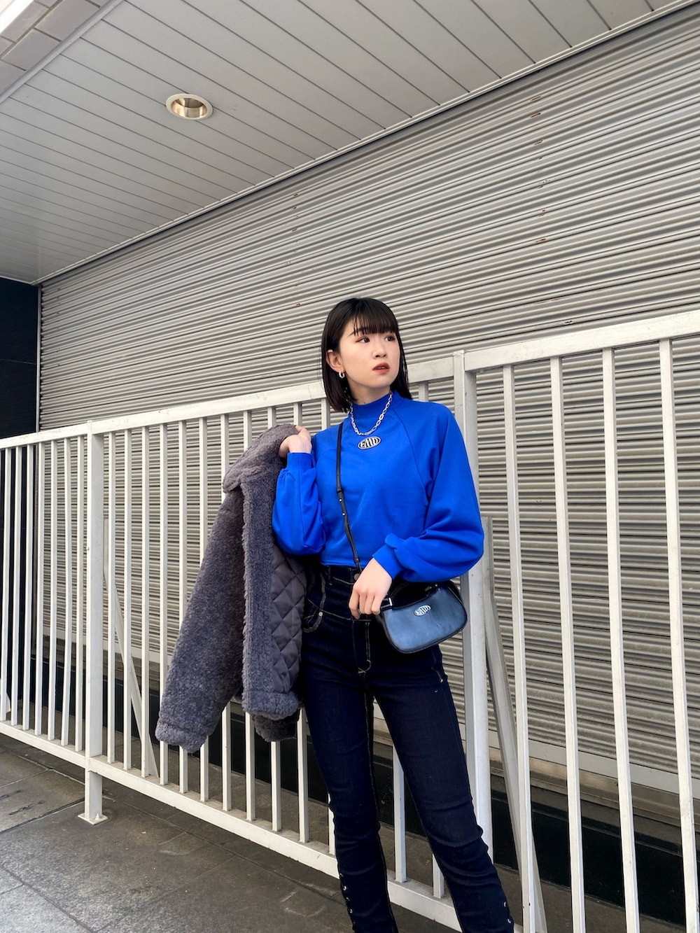 ブルー系のデニムパンツ、ブラック系のブーツ、ブルー系のスウェットを着用したレディースの冬コーディネートの7枚目の写真
