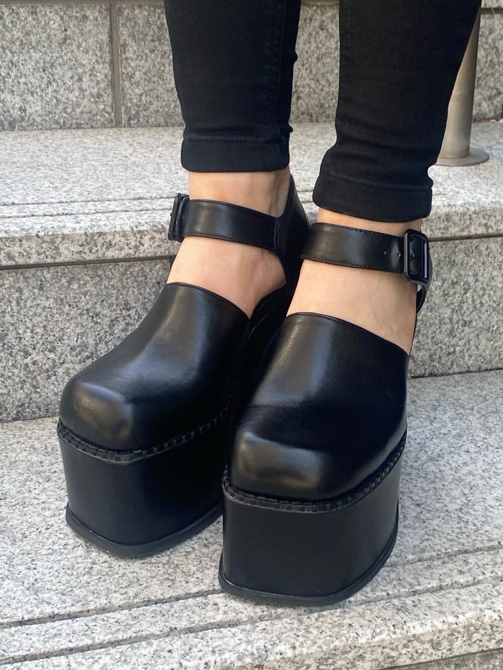 ブラック系のサンダル、ブラック系のハンドバッグ、ブルー系のデニムパンツを着用したレディースの春コーディネートの10枚目の写真