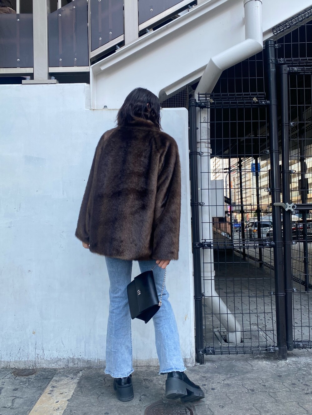 ブルー系のデニムパンツ、ブラック系のブーツ、ブラウン系のその他アウターを着用したレディースの冬コーディネートの4枚目の写真