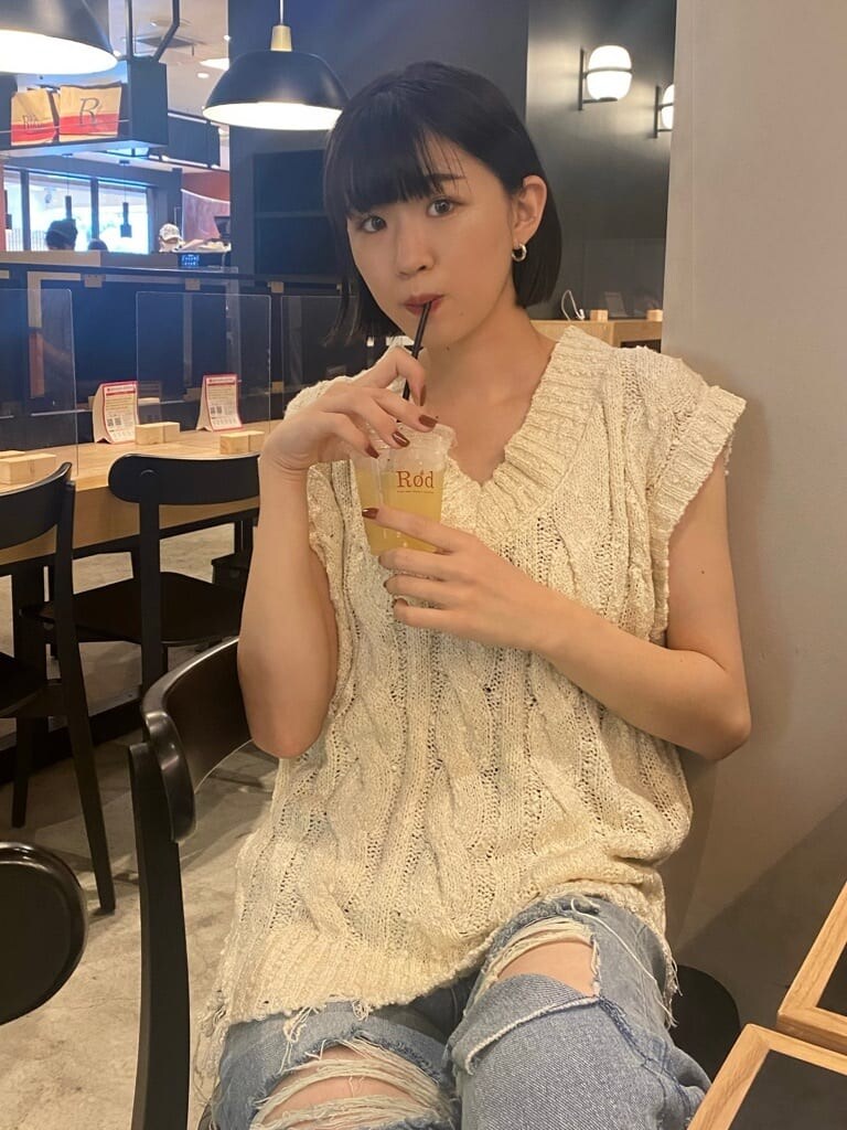 ブルー系のデニムパンツ、ベージュ系のスリッポン、ホワイト系のベストを着用したレディースの夏コーディネートの6枚目の写真