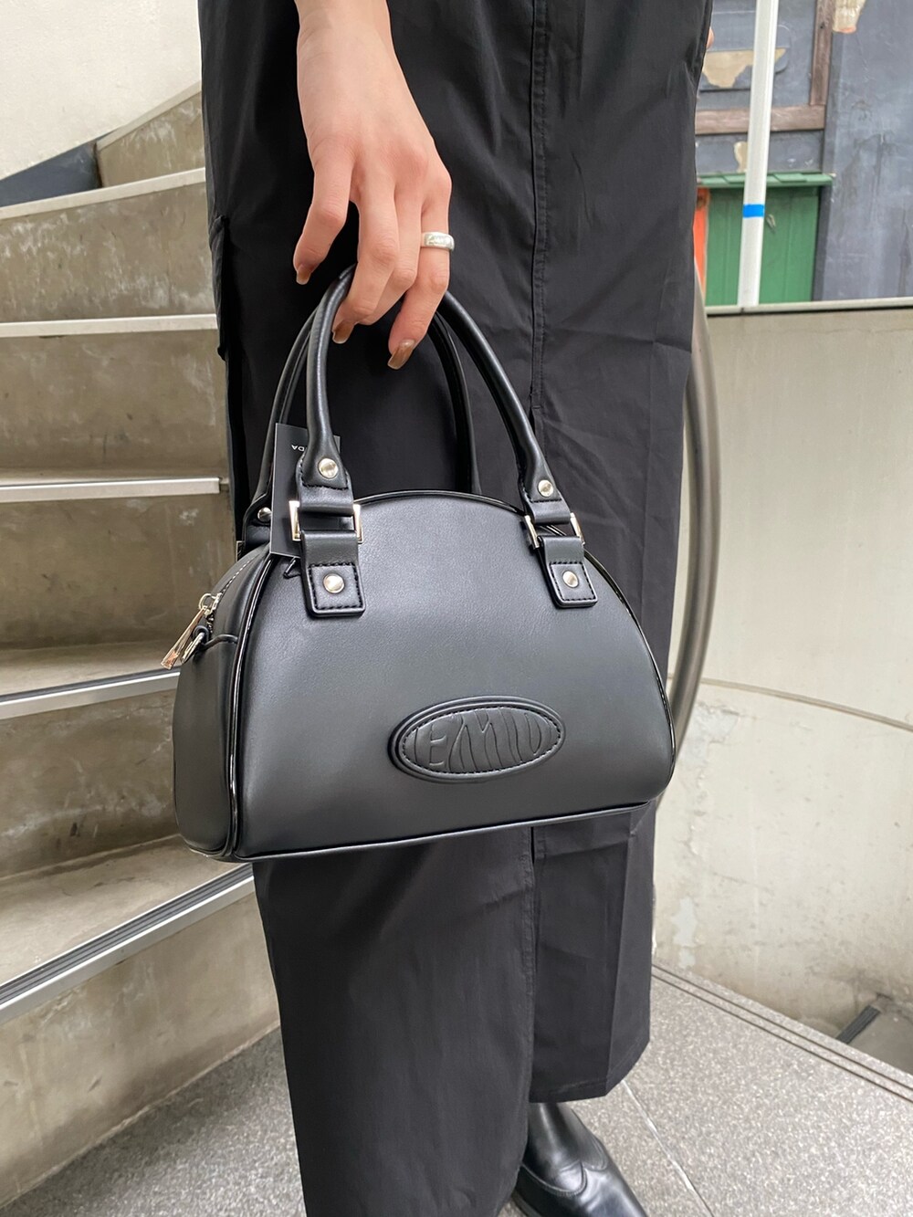 ブラック系のスカート、ブラック系のハンドバッグ、グリーン系のTシャツ/カットソーを着用したレディースの春コーディネートの10枚目の写真