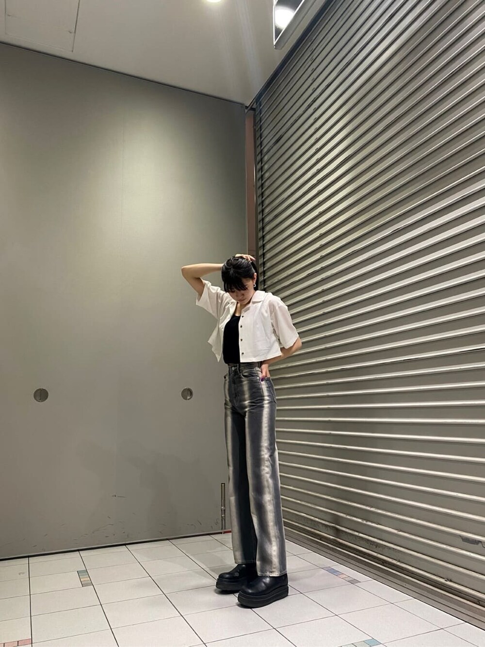 ブラック系のデニムパンツ、ブラック系のタンクトップ、ホワイト系のシャツ/ブラウスを着用したレディースの春コーディネートの5枚目の写真