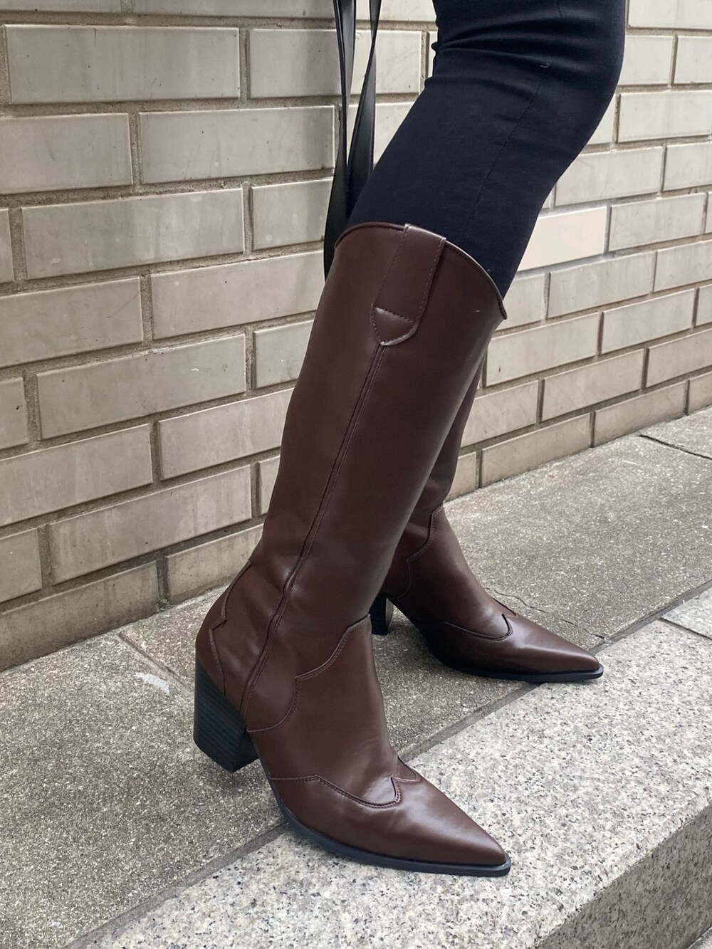 ブラック系のブーツ、ブラック系のデニムパンツ、ホワイト系のブルゾンを着用したレディースの冬コーディネートの9枚目の写真