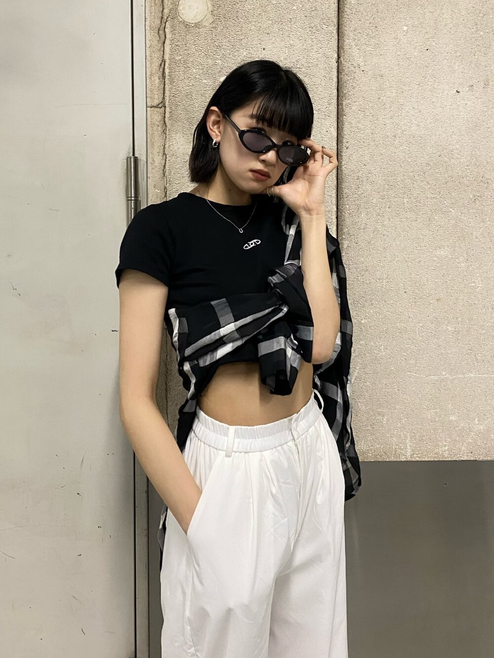 ホワイト系のその他パンツ、ブラック系のブーツ、ブラック系のTシャツ/カットソーを着用したレディースの春コーディネートの6枚目の写真