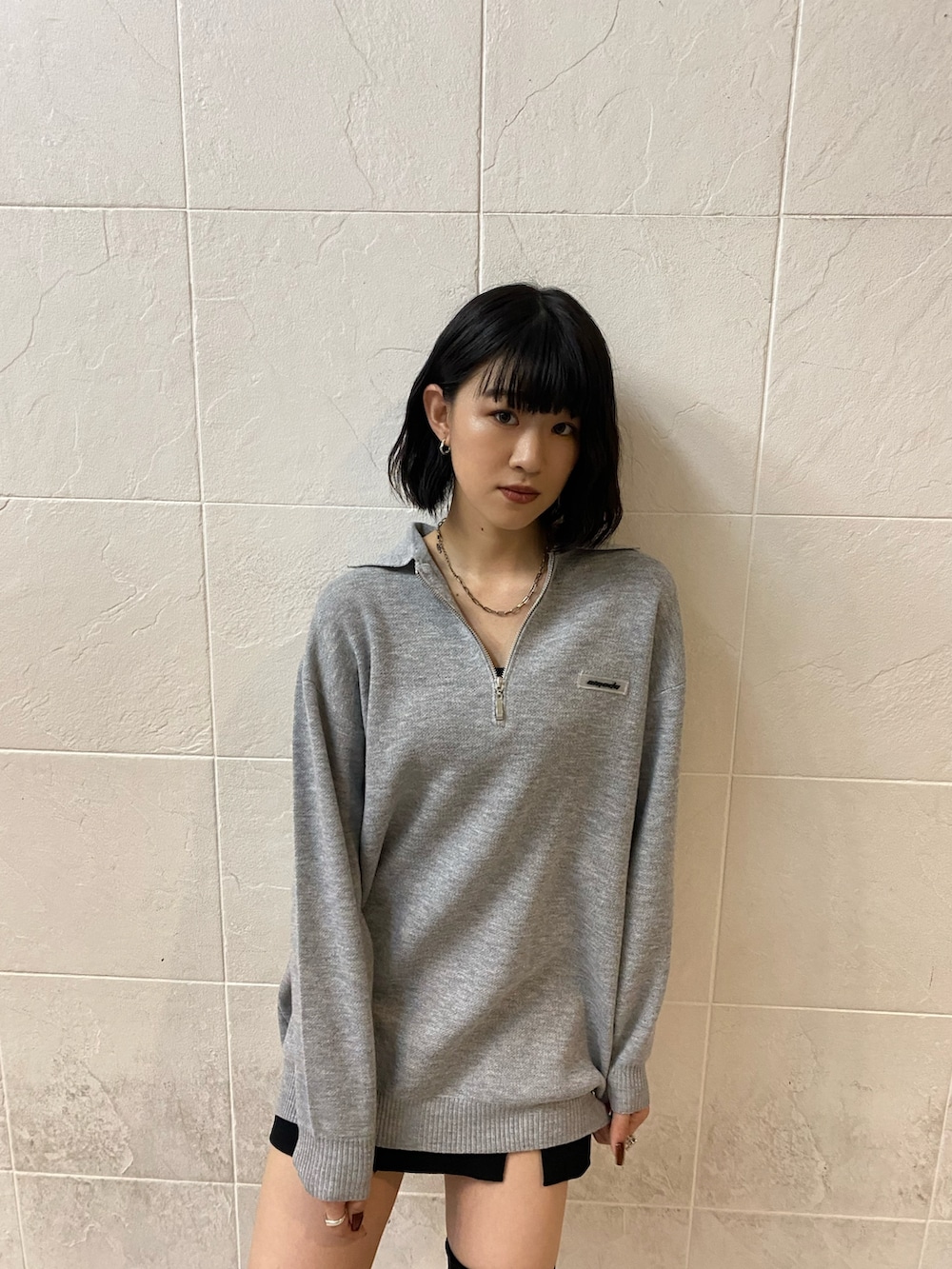 ブラック系のブーツ、グレー系のワンピース、ブラック系のスカートを着用したレディースの秋コーディネートの6枚目の写真