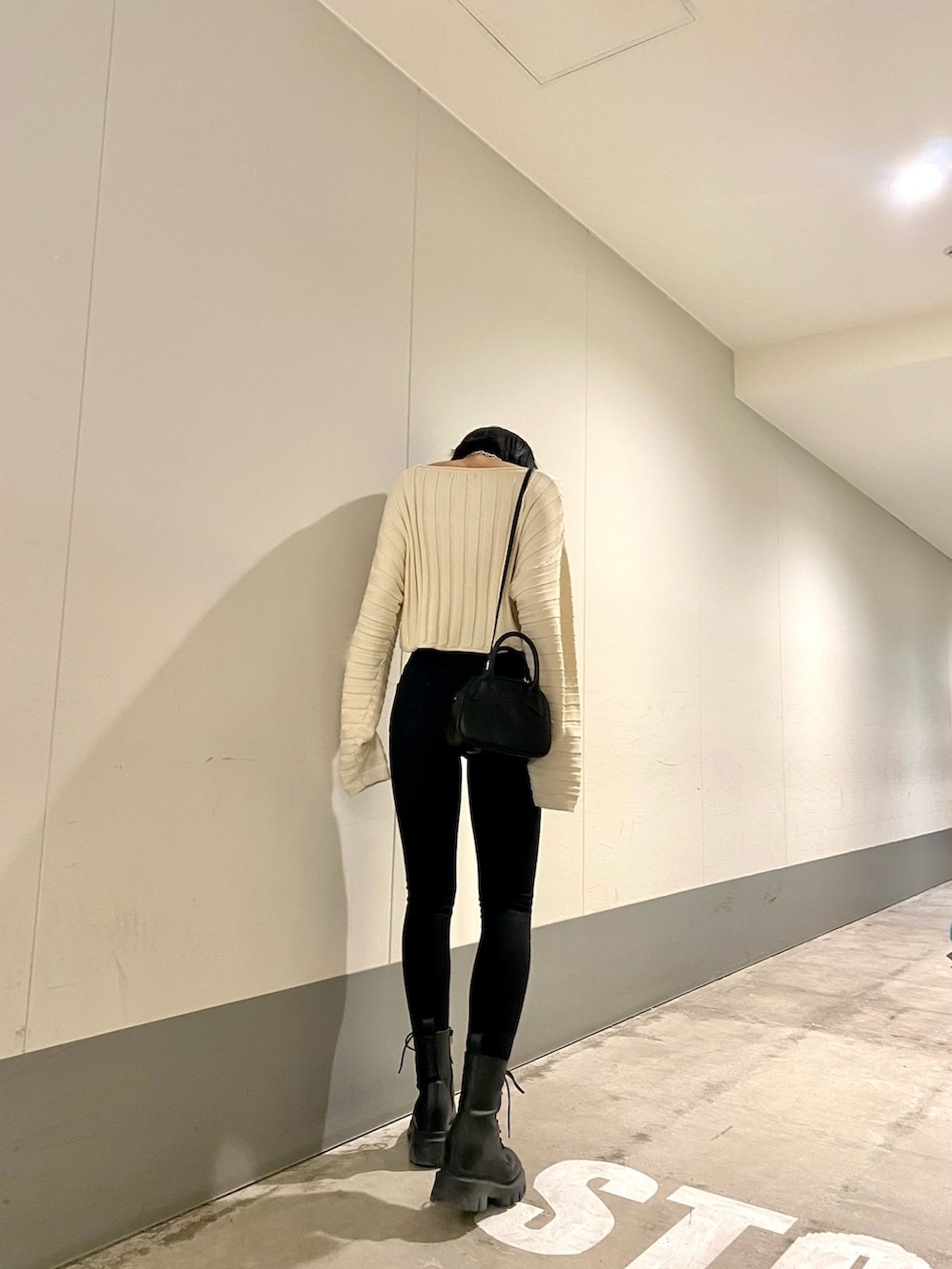 ブラック系のブーツ、ブラック系のデニムパンツ、ホワイト系のニット/セーターを着用したレディースの春コーディネートの4枚目の写真