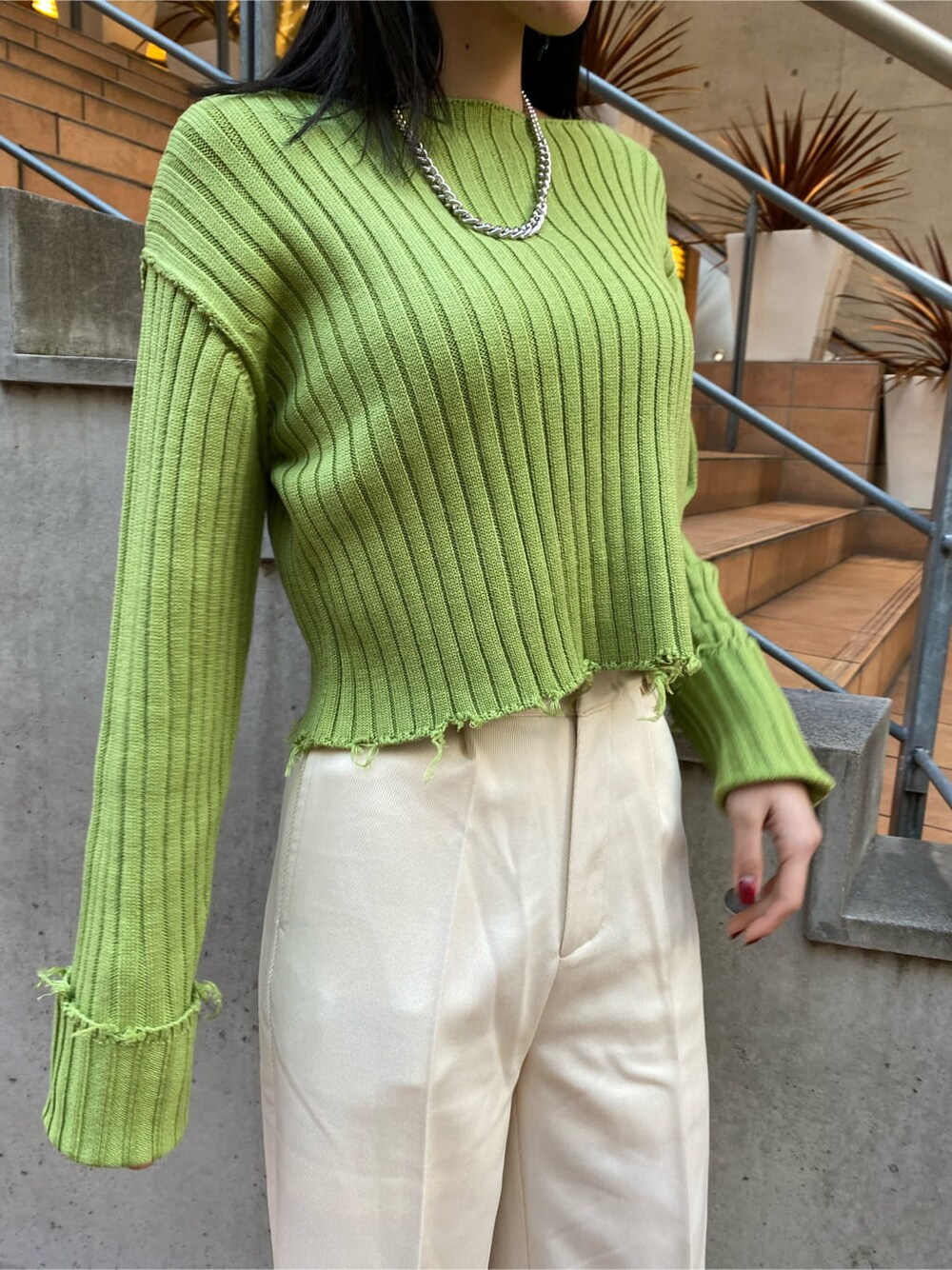 ブラック系のブーツ、ホワイト系のその他パンツ、イエロー系のニット/セーターを着用したレディースの冬コーディネートの5枚目の写真