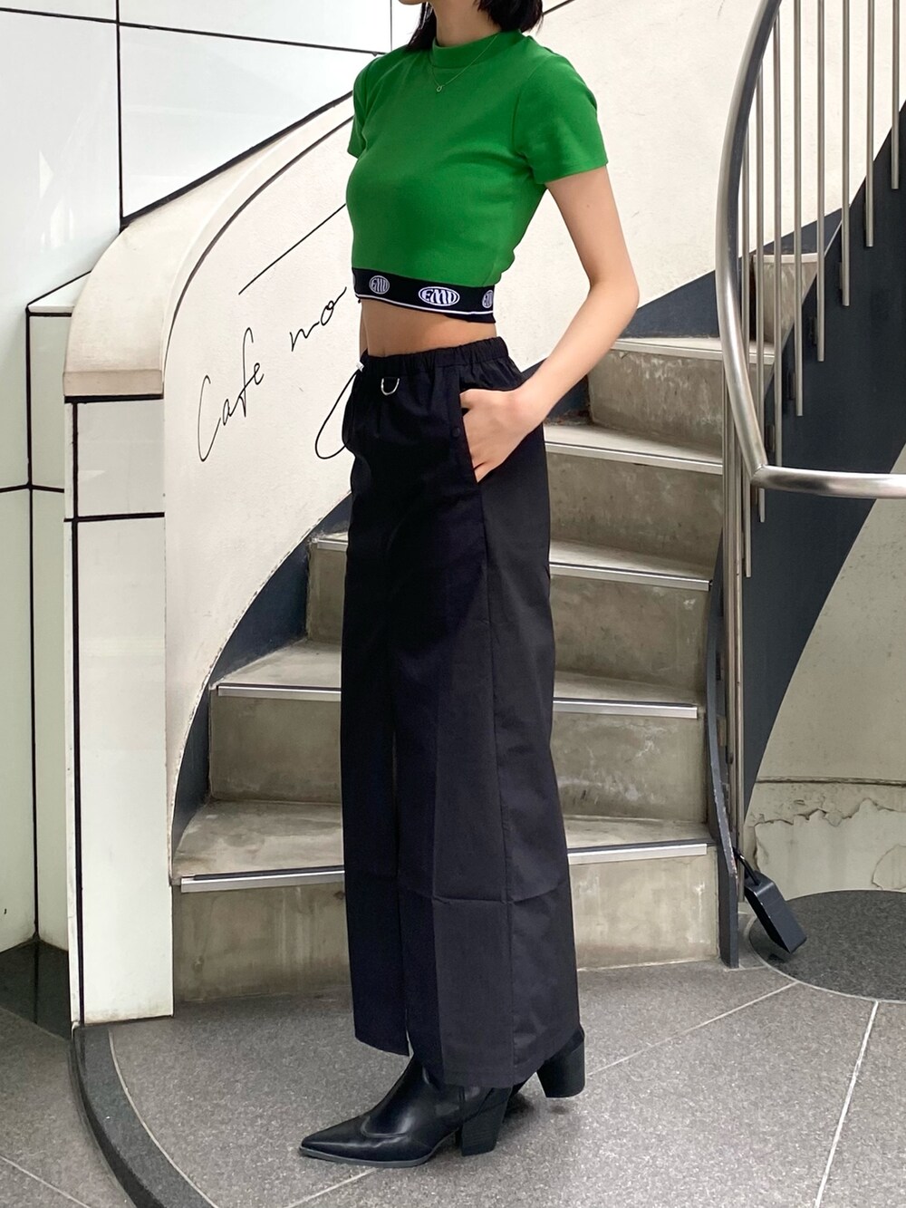 ブラック系のスカート、ブラック系のハンドバッグ、グリーン系のTシャツ/カットソーを着用したレディースの春コーディネートの3枚目の写真