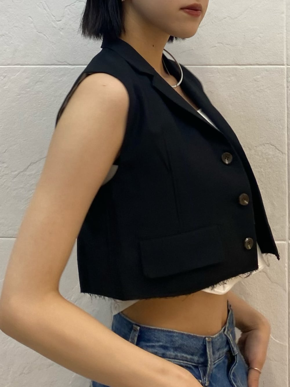 ブラック系のサンダル、ブルー系のデニムパンツ、ホワイト系のニット/セーターを着用したレディースの夏コーディネートの7枚目の写真