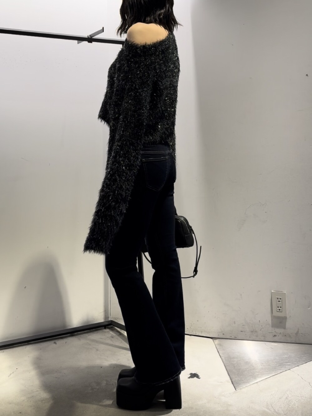 ブラック系のハンドバッグ、ブラック系のニット/セーター、ブルー系のデニムパンツを着用したレディースの冬コーディネートの6枚目の写真