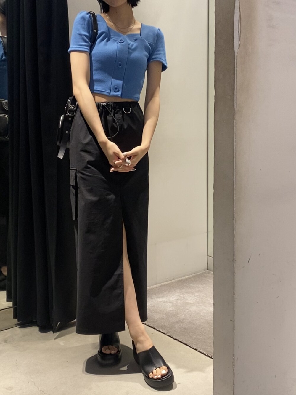 ブラック系のサンダル、ブラック系のスカート、ブルー系のTシャツ/カットソーを着用したレディースの春コーディネートの6枚目の写真