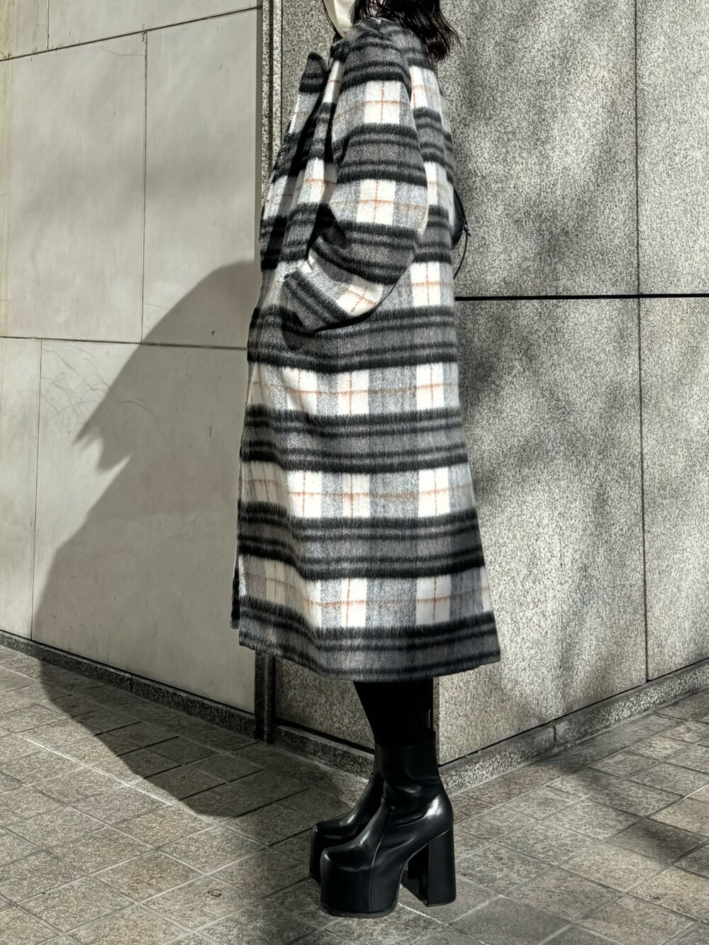 ブラック系のブーツ、ブルー系のデニムパンツ、その他のチェスターコートを着用したレディースの冬コーディネートの3枚目の写真