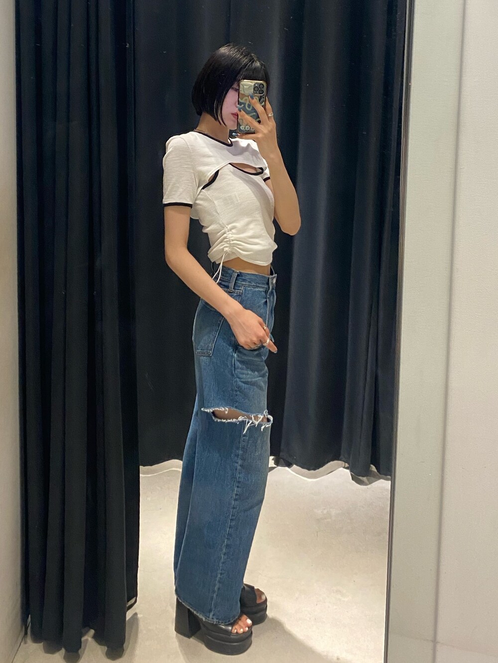 ブラック系のサンダル、ブルー系のデニムパンツ、ホワイト系のTシャツ/カットソーを着用したレディースの夏コーディネートの2枚目の写真