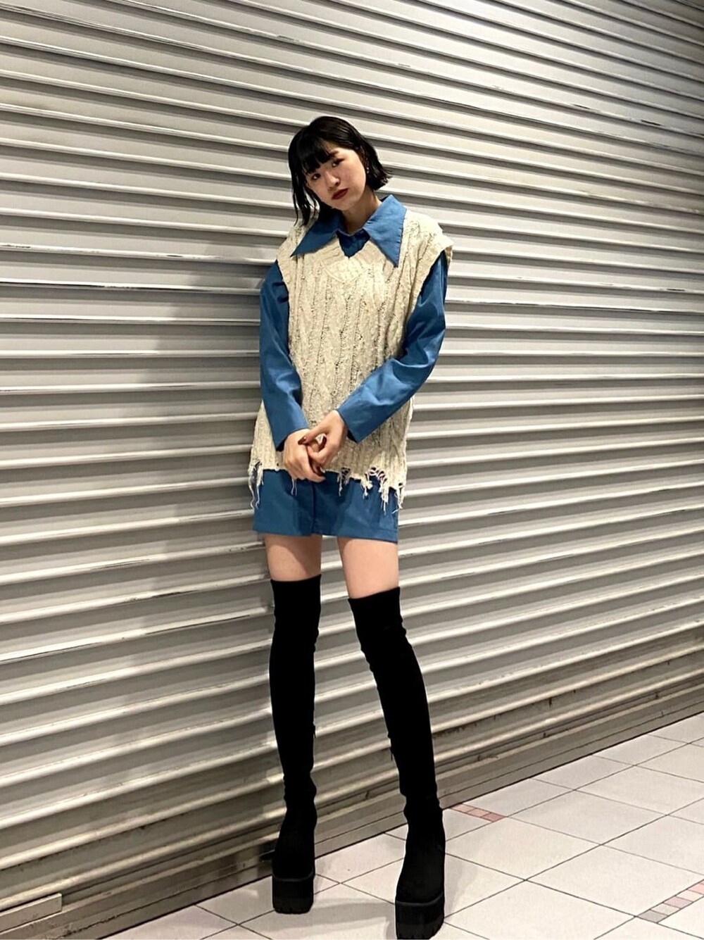 ホワイト系のベスト、ブルー系のワンピース、ブラック系のブーツを着用したレディースの夏コーディネートの3枚目の写真