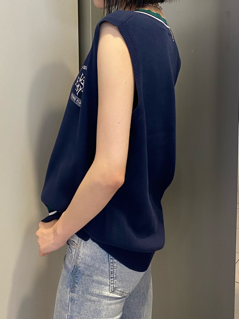 ブラック系のサンダル、ブルー系のデニムパンツ、ブルー系のベストを着用したレディースの春コーディネートの7枚目の写真