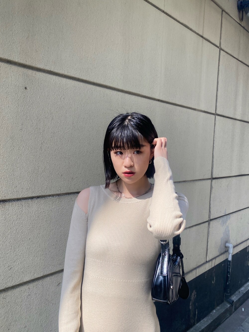 ブラック系のブーツ、ベージュ系のワンピース、ブラック系のデニムジャケットを着用したレディースの春コーディネートの6枚目の写真