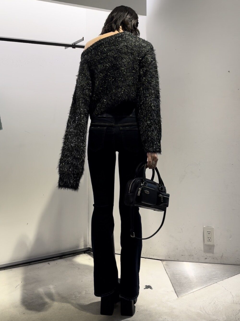 ブラック系のハンドバッグ、ブラック系のニット/セーター、ブルー系のデニムパンツを着用したレディースの冬コーディネートの8枚目の写真