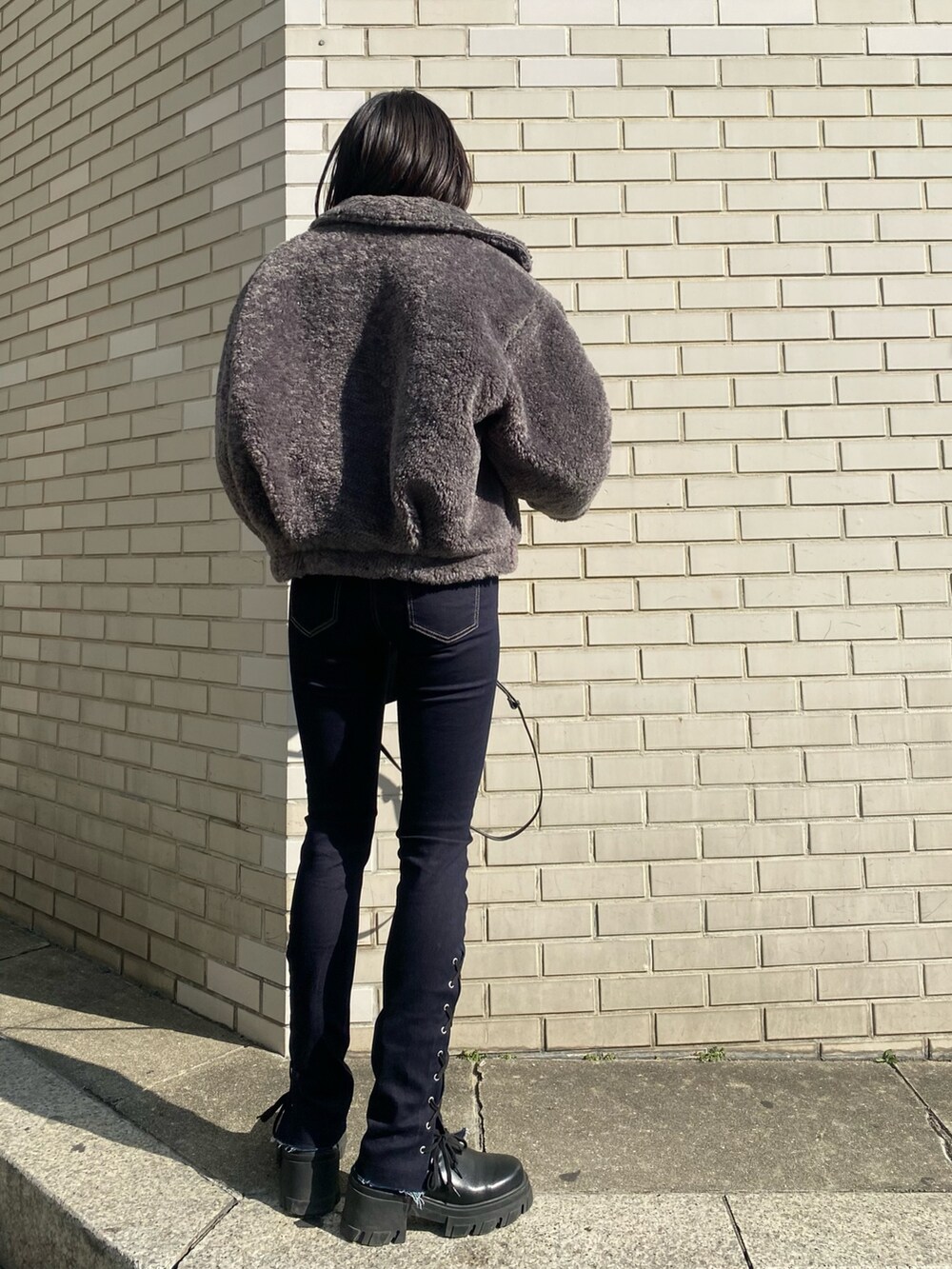 ブラック系のブーツ、ブラック系のハンドバッグ、グレー系のブルゾンを着用したレディースの冬コーディネートの4枚目の写真