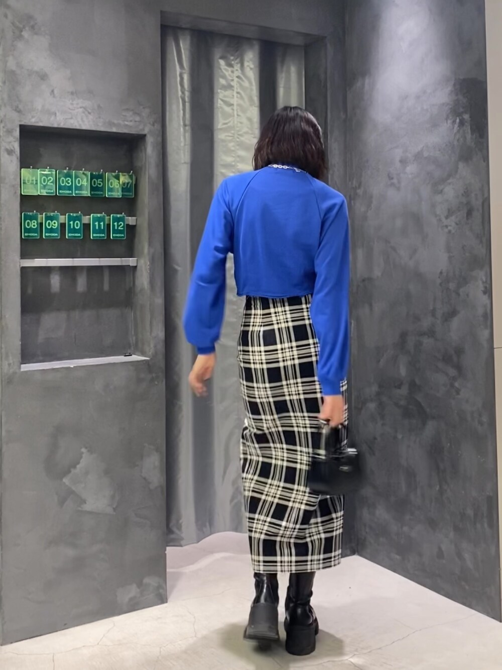 その他のスカート、ブラック系のブーツ、ブラック系のハンドバッグを着用したレディースの冬コーディネートの8枚目の写真