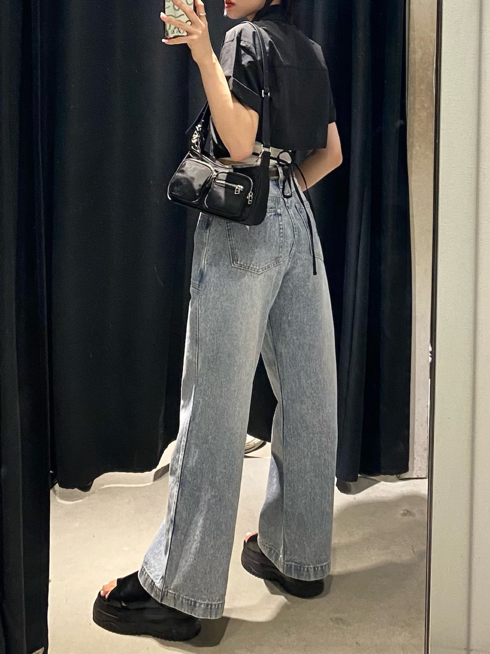 ブラック系のサンダル、ブルー系のデニムパンツ、ブラック系のシャツ/ブラウスを着用したレディースの夏コーディネートの3枚目の写真