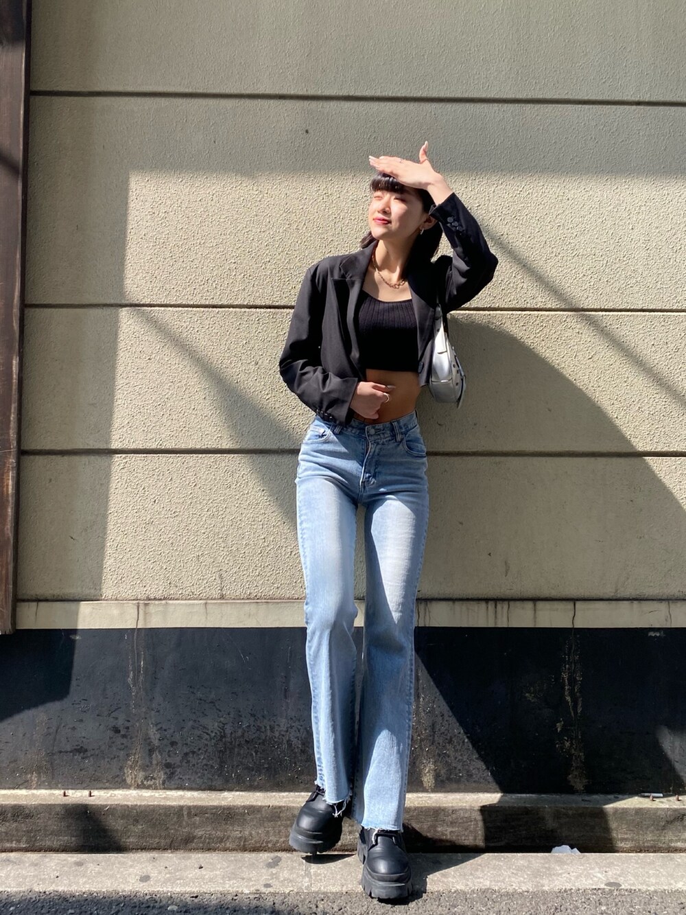 ブラック系のブーツ、ブルー系のデニムパンツ、ブラック系のTシャツ/カットソーを着用したレディースの春コーディネートの3枚目の写真