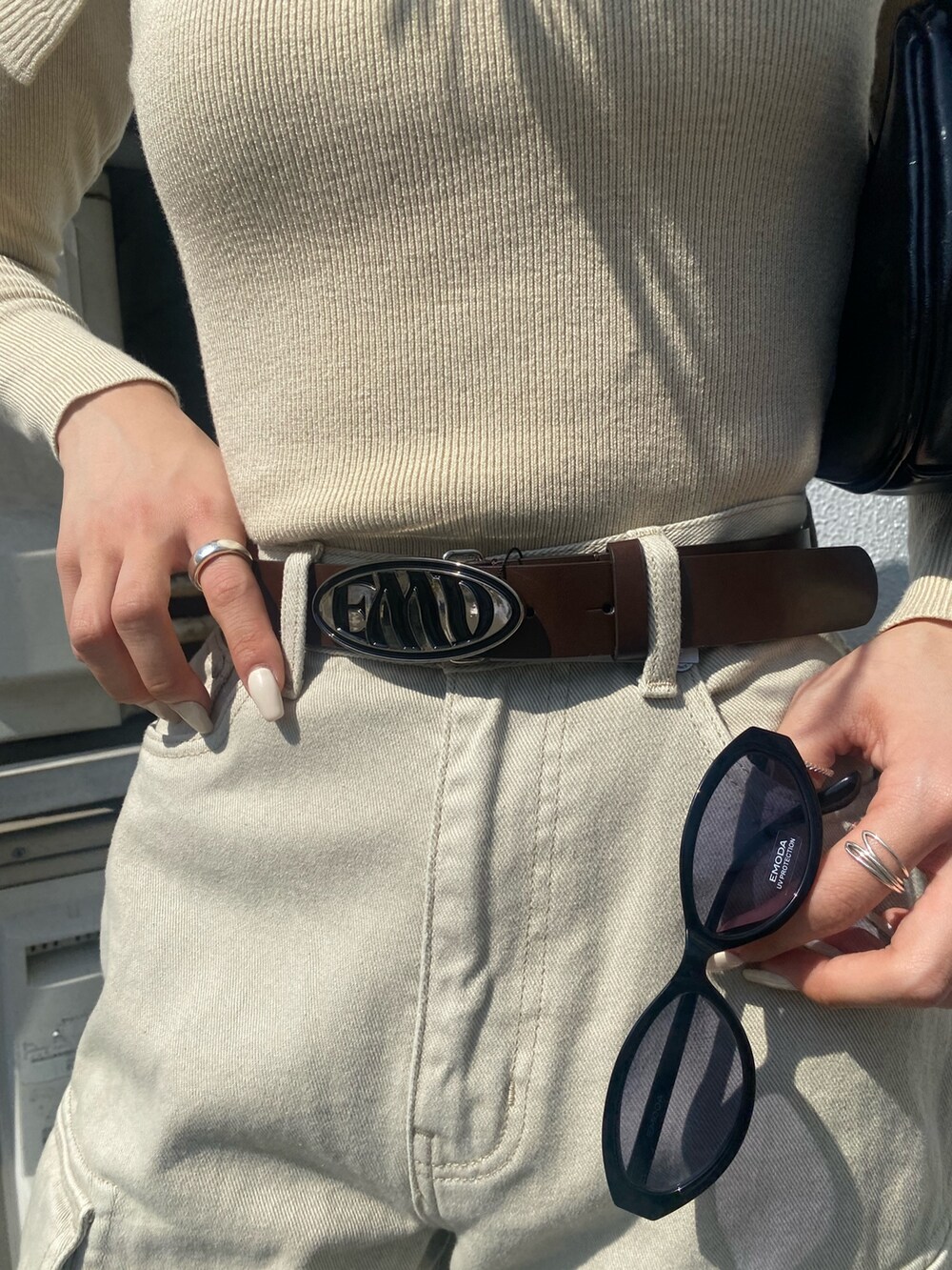 ブラウン系のブーツ、ホワイト系のデニムパンツ、ブラック系のハンドバッグを着用したレディースの春コーディネートの10枚目の写真