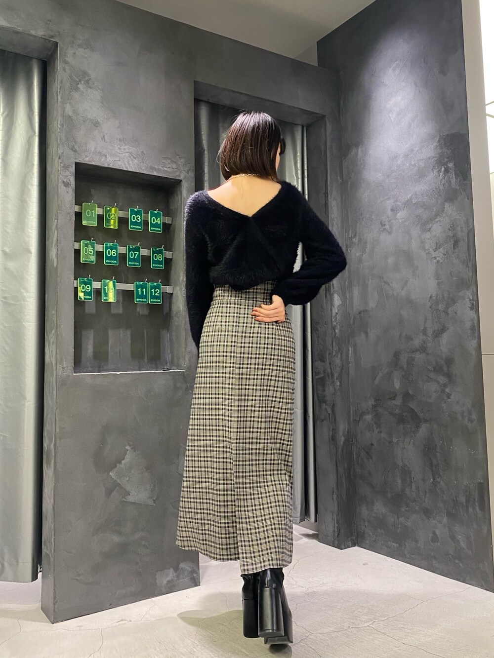 ブラック系のブーツ、ブラック系のニット/セーター、その他のスカートを着用したレディースの冬コーディネートの6枚目の写真