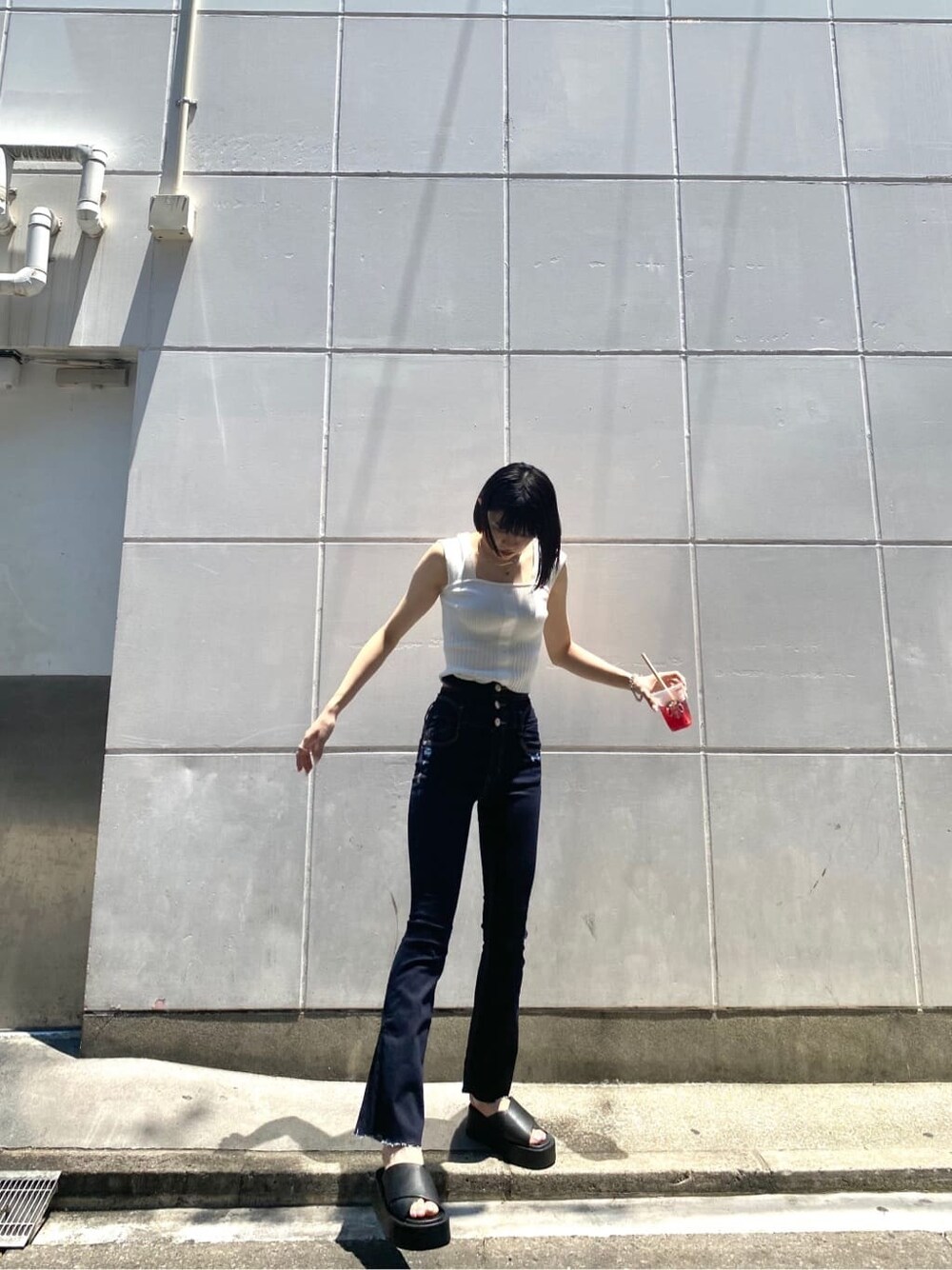ブルー系のデニムパンツ、ホワイト系のタンクトップを着用したレディースの夏コーディネートの2枚目の写真