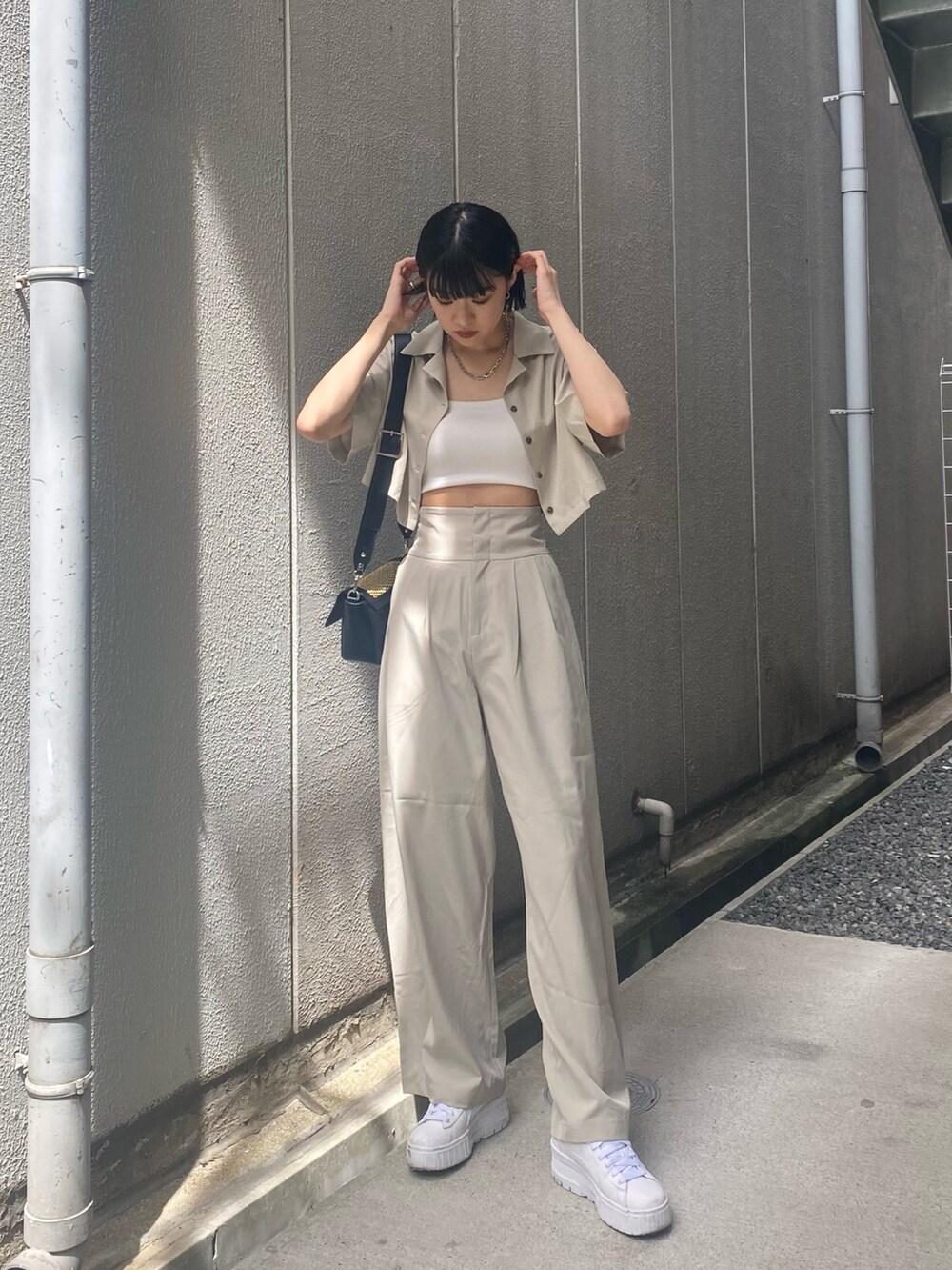 ベージュ系のその他パンツ、ホワイト系のキャミソール、ベージュ系のショルダーバッグを着用したレディースの夏コーディネートの2枚目の写真