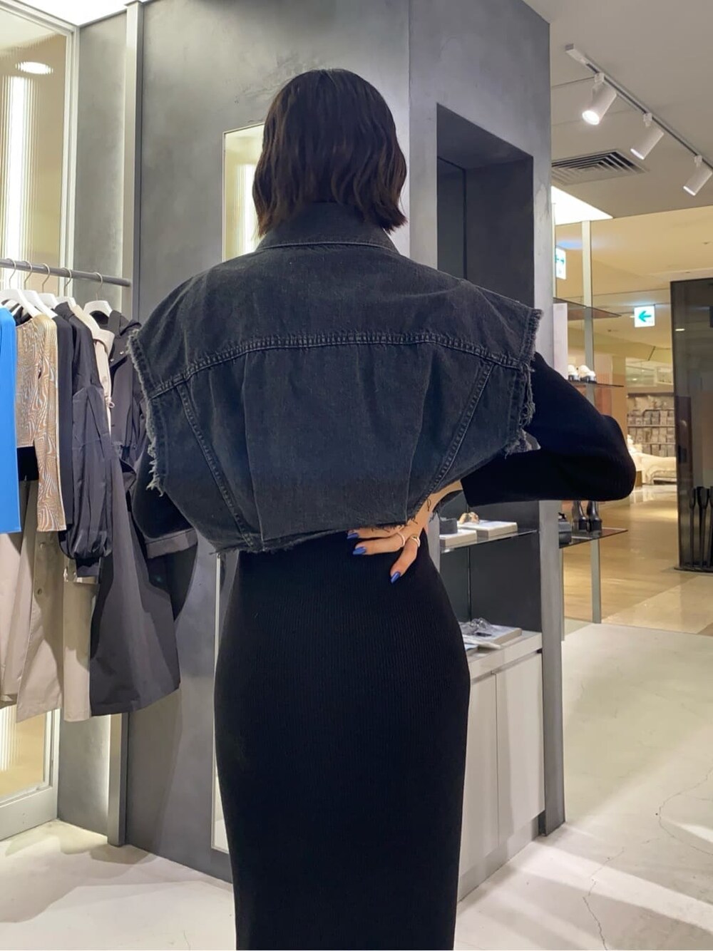 ブラック系のブーツ、ブラック系のワンピース、ブラウン系のハンドバッグを着用したレディースの秋コーディネートの5枚目の写真