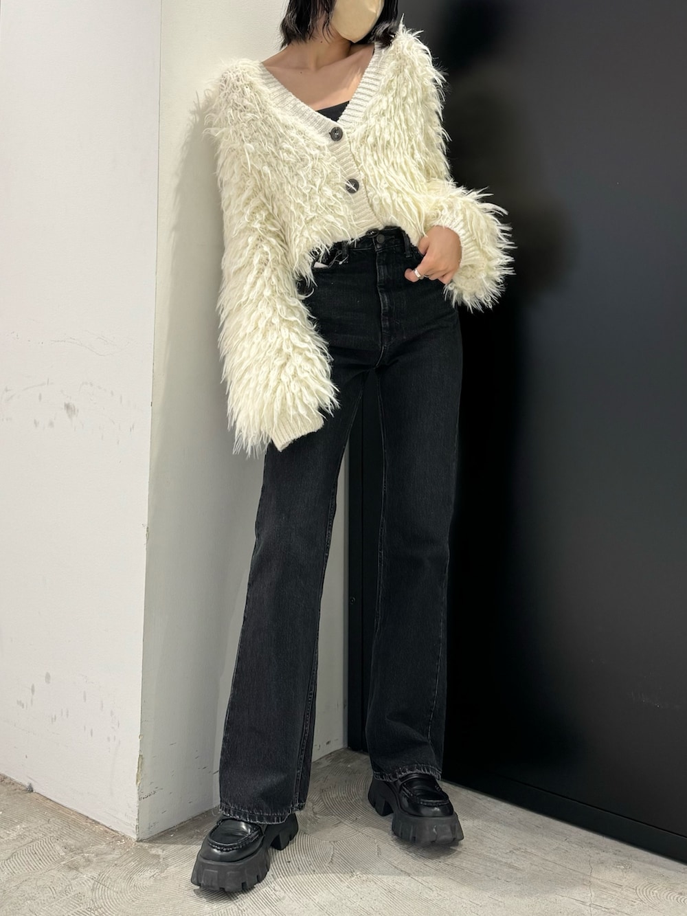 ブラック系のデニムパンツ、ホワイト系のカーディガン/ボレロを着用したレディースの秋コーディネートの2枚目の写真