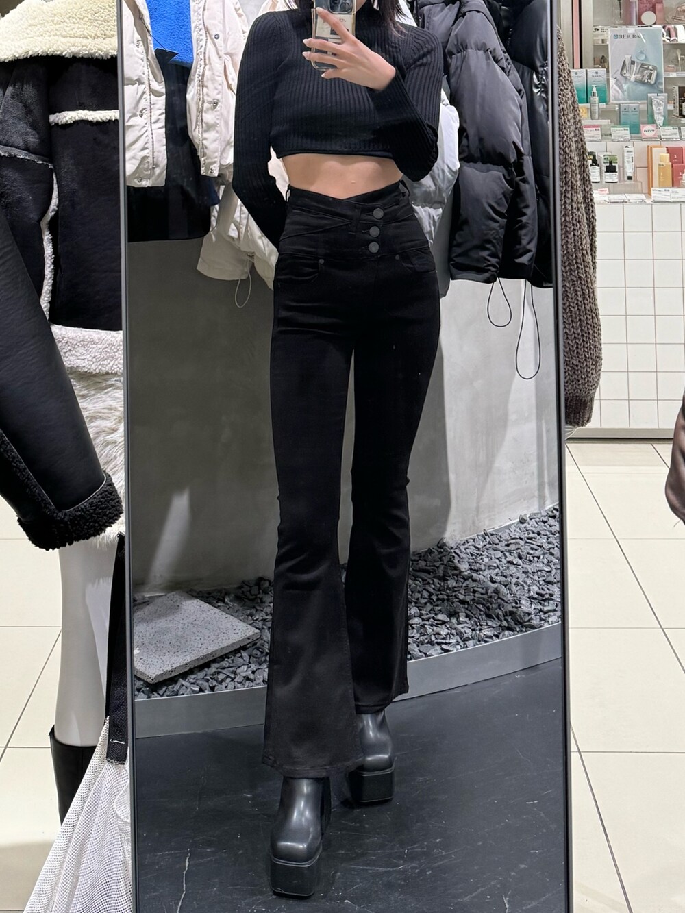 ブラック系のブーツ、ブラック系のデニムパンツ、ブラック系のニット/セーターを着用したレディースの冬コーディネートの5枚目の写真