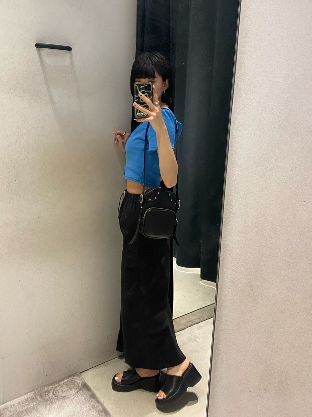 ブラック系のサンダル、ブラック系のスカート、ブルー系のTシャツ/カットソーを着用したレディースの春コーディネートの2枚目の写真