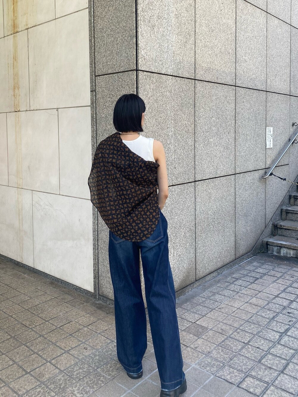 ブラック系のサンダル、ブルー系のデニムパンツ、ホワイト系のタンクトップを着用したレディースの夏コーディネートの4枚目の写真