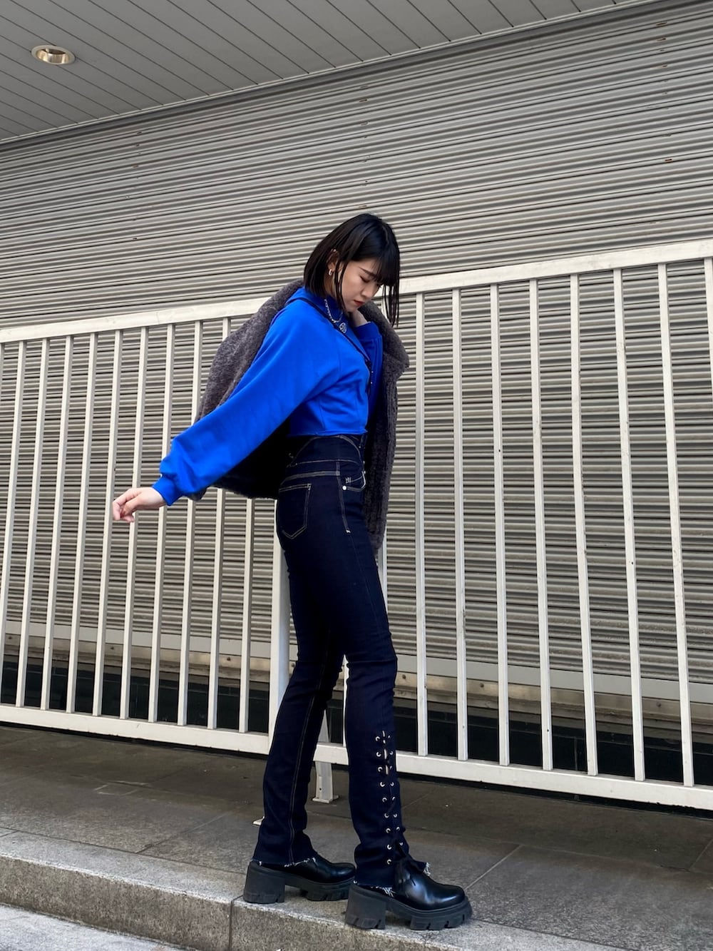 ブルー系のデニムパンツ、ブラック系のブーツ、ブルー系のスウェットを着用したレディースの冬コーディネートの4枚目の写真