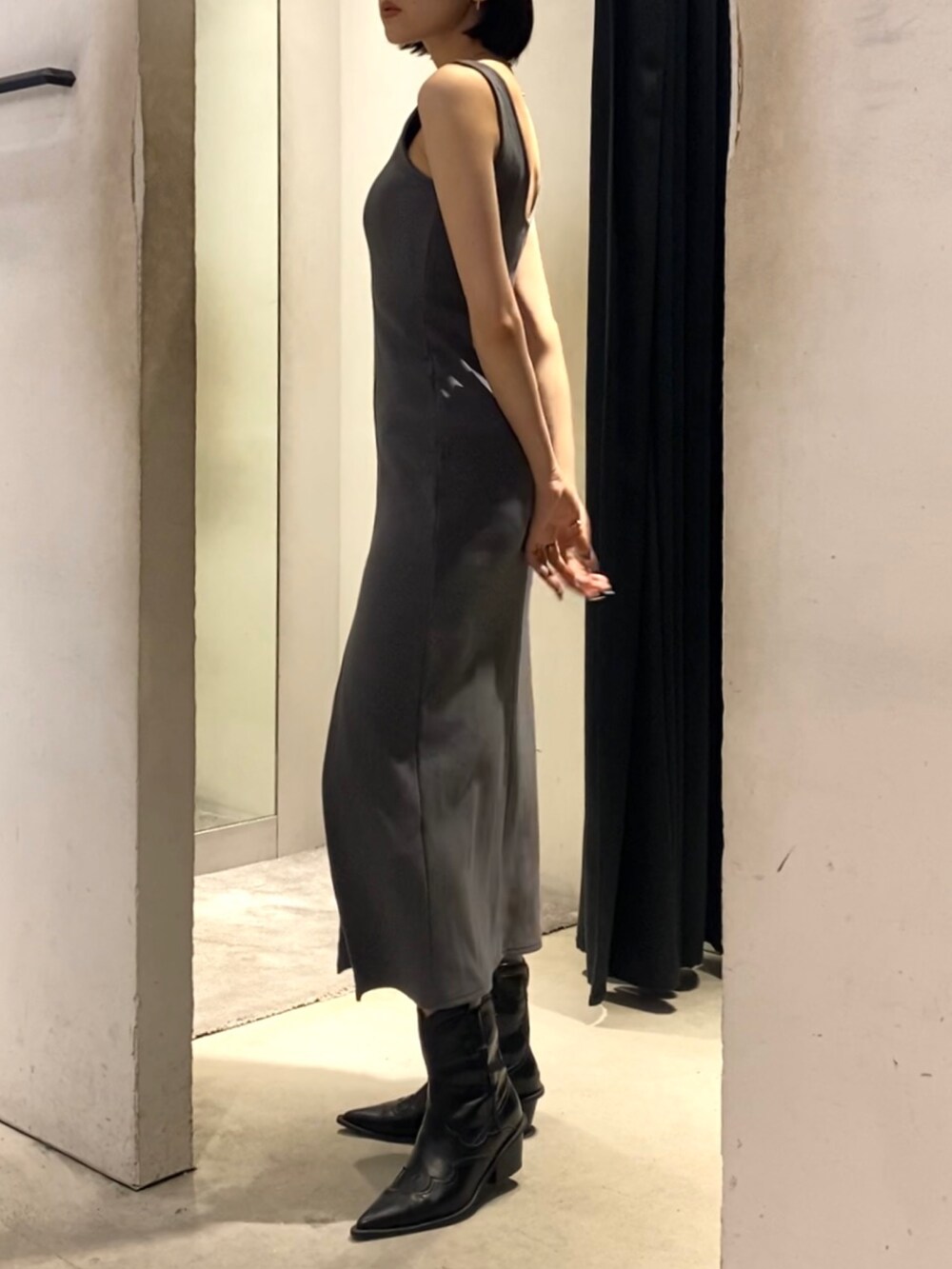 グレー系のワンピース、ブラック系のブーツを着用したレディースの夏コーディネートの3枚目の写真