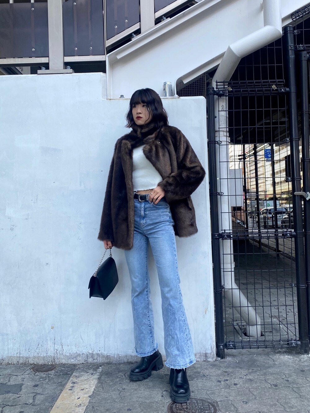 ブルー系のデニムパンツ、ブラック系のブーツ、ブラウン系のその他アウターを着用したレディースの冬コーディネートの3枚目の写真