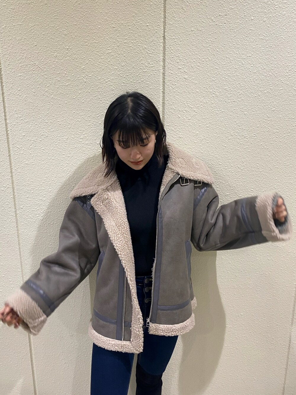 ブルー系のデニムパンツ、グレー系のブルゾン、ブラック系のニット/セーターを着用したレディースの冬コーディネートの4枚目の写真