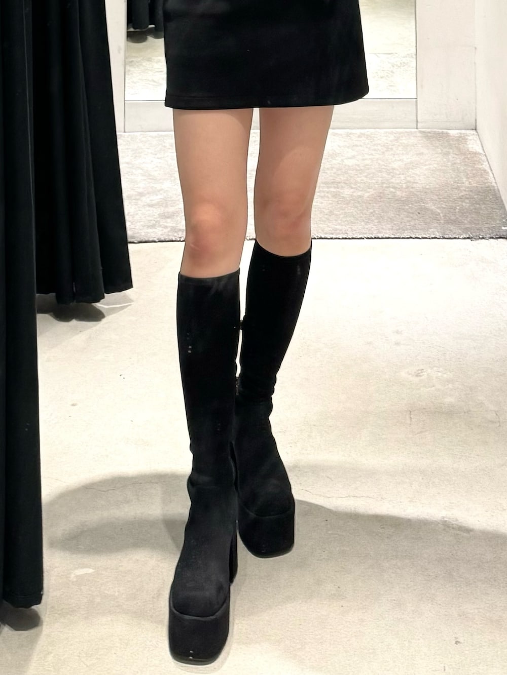 その他のブーツ、ブラック系のスカート、その他のカーディガン/ボレロを着用したレディースの秋コーディネートの7枚目の写真