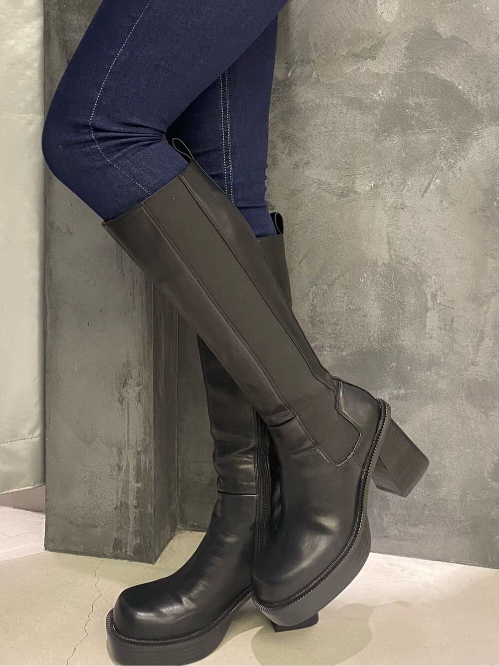 ブラック系のブーツ、その他のテーラードジャケット、ブルー系のデニムパンツを着用したレディースの秋コーディネートの5枚目の写真