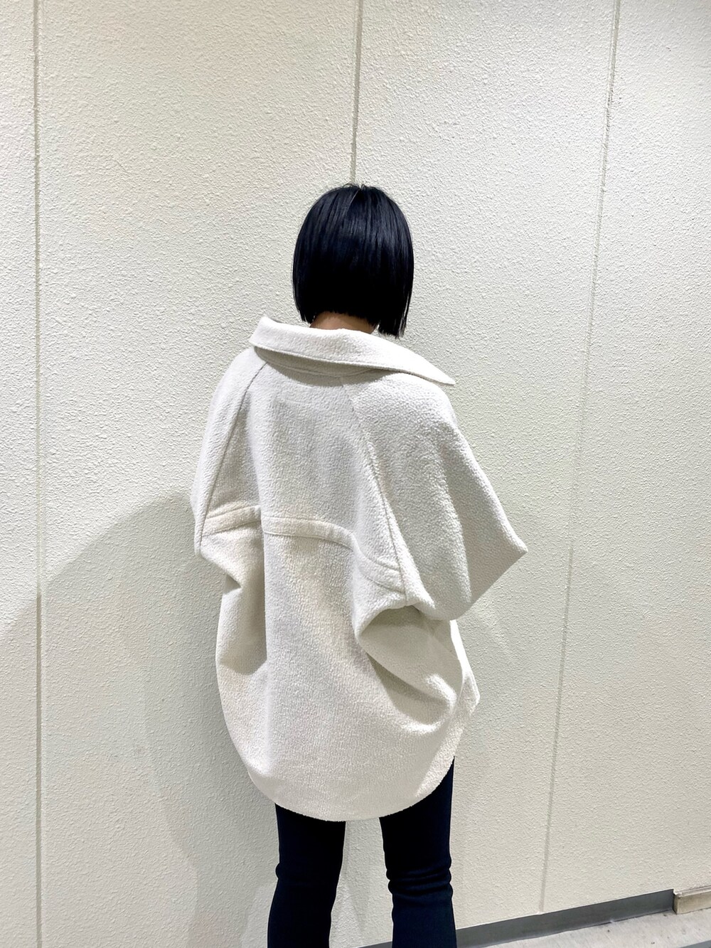 ホワイト系のブルゾン、ブラック系のその他パンツ、ブラック系のブーツを着用したレディースの冬コーディネートの5枚目の写真